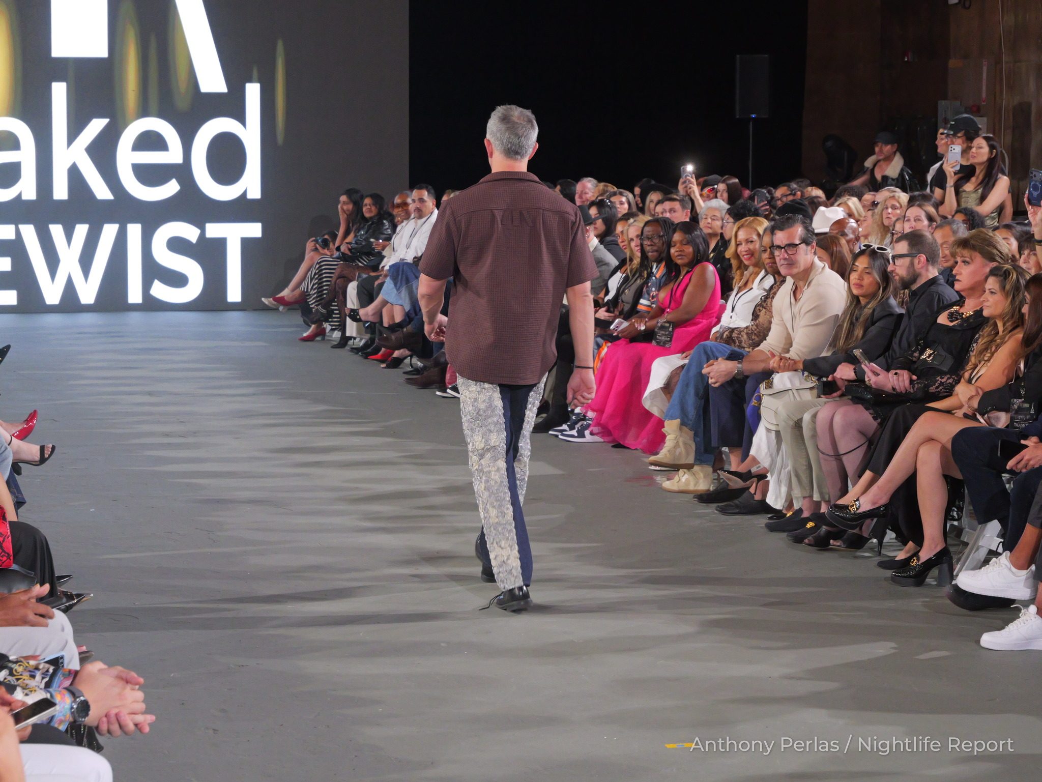 Runway look by Naked Sewist (Doug Chinery) at The Bureau Fashion Week LA, The Finale: rear view of the brown shirt and panelled navy and silver trousers.