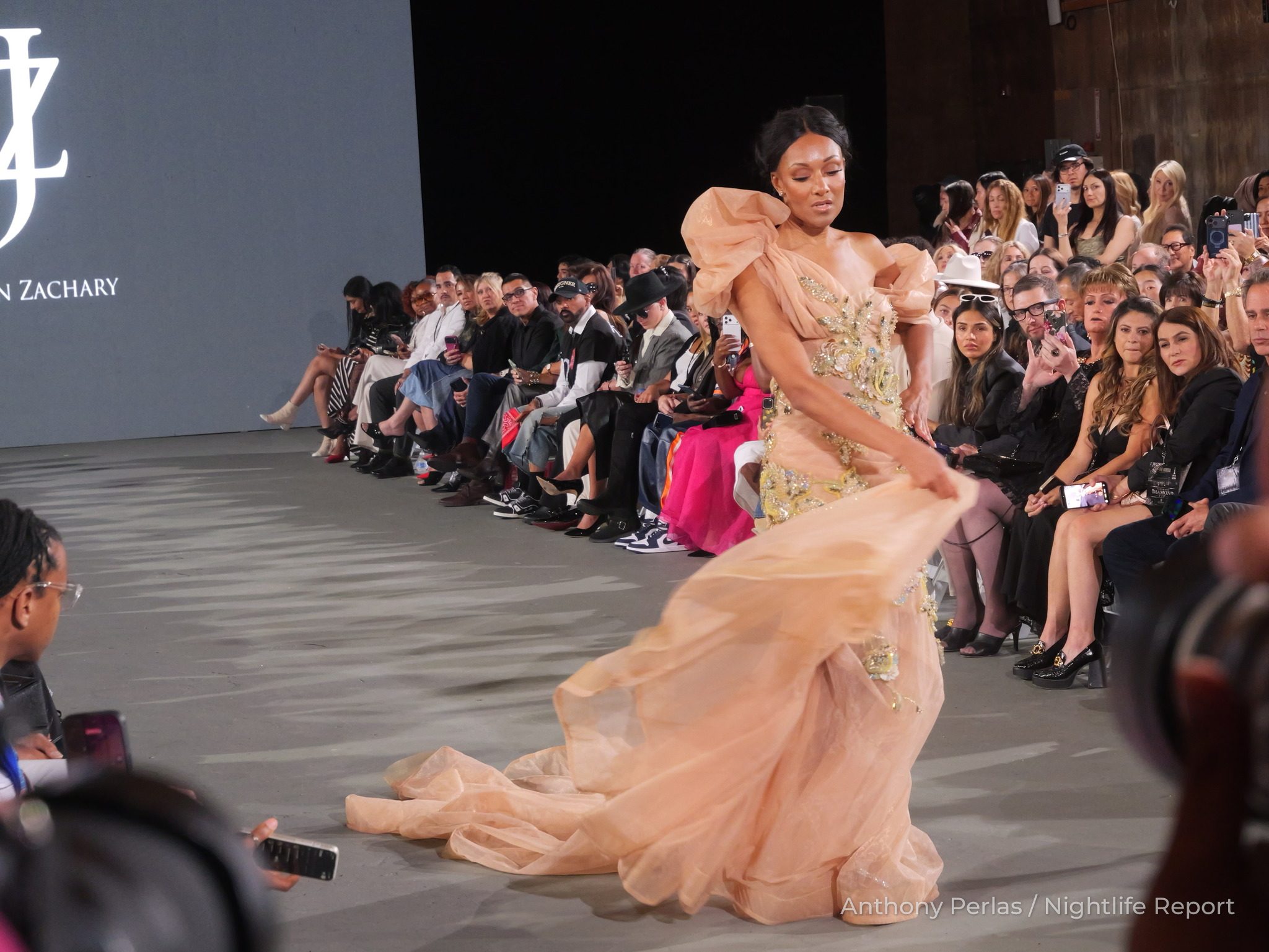 Runway look by Justin Zachary at The Bureau Fashion Week LA, The Finale: peach tulle gown with sculpted ruffled shoulders and a sweeping train.