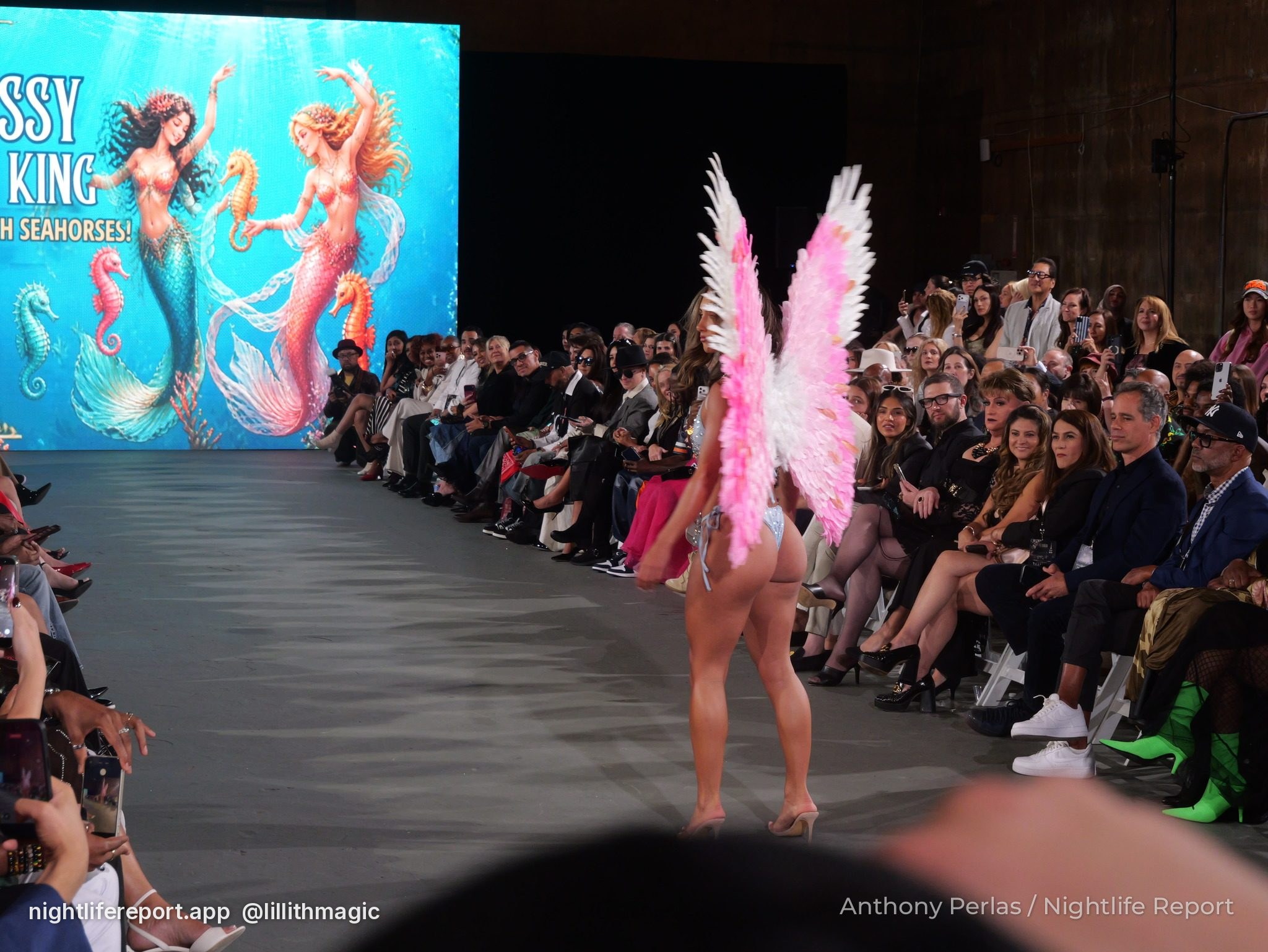 Pink-and-white feather wings walking toward the mermaid screen, Krissy King Swim at The Bureau Fashion Week LA, The Finale