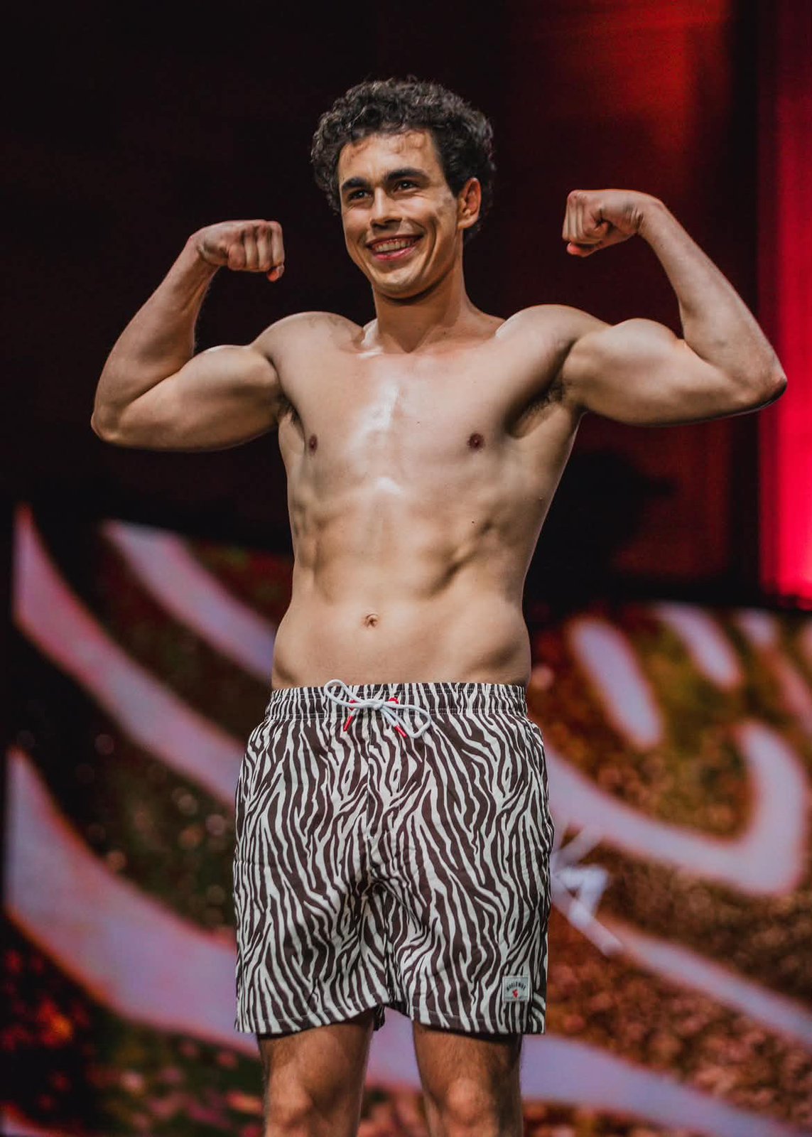 Kevin Fernandez flexes for the crowd on the runway in zebra-print swim shorts