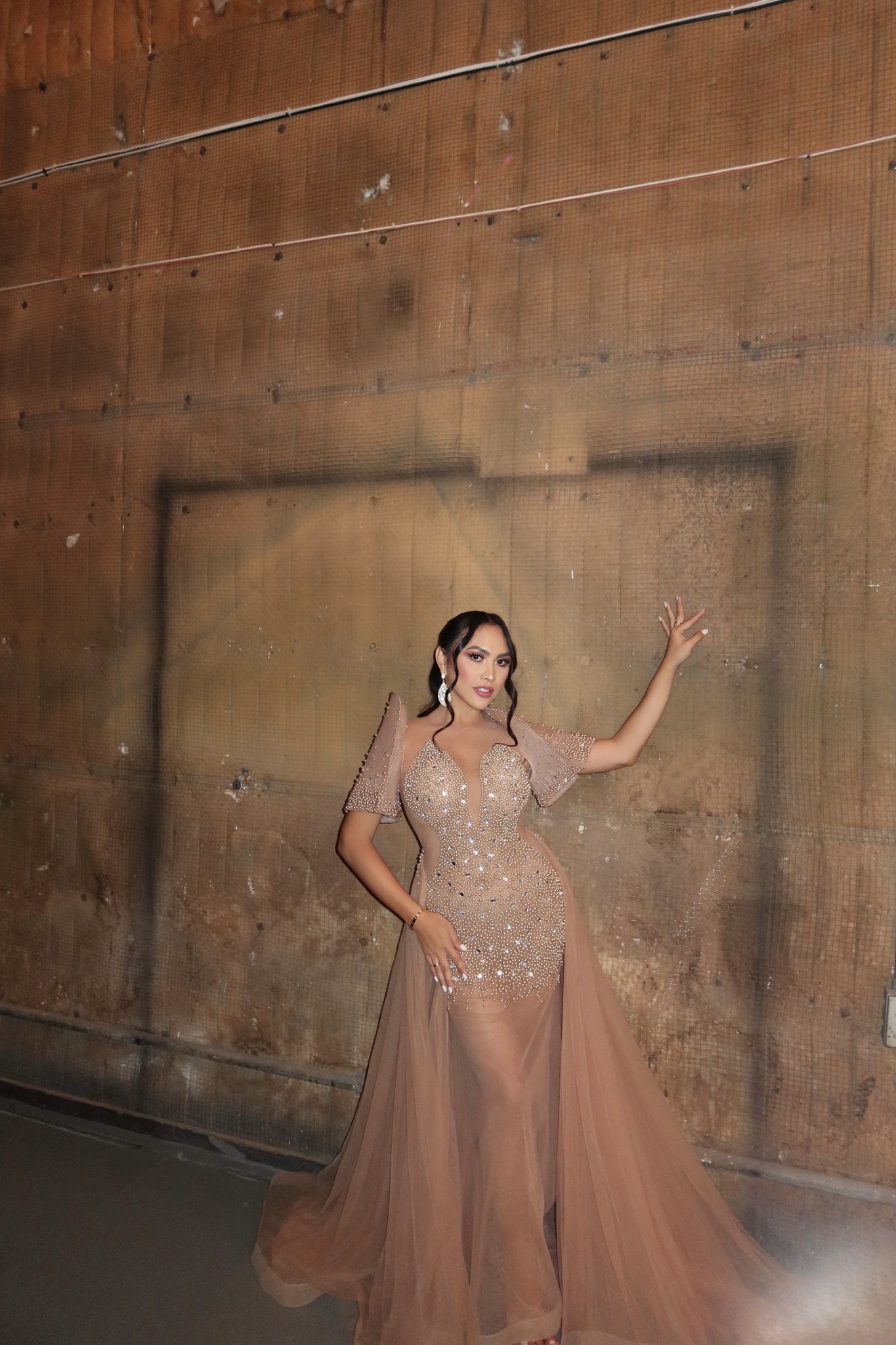 Sofhia Flores in a gown against a brick wall