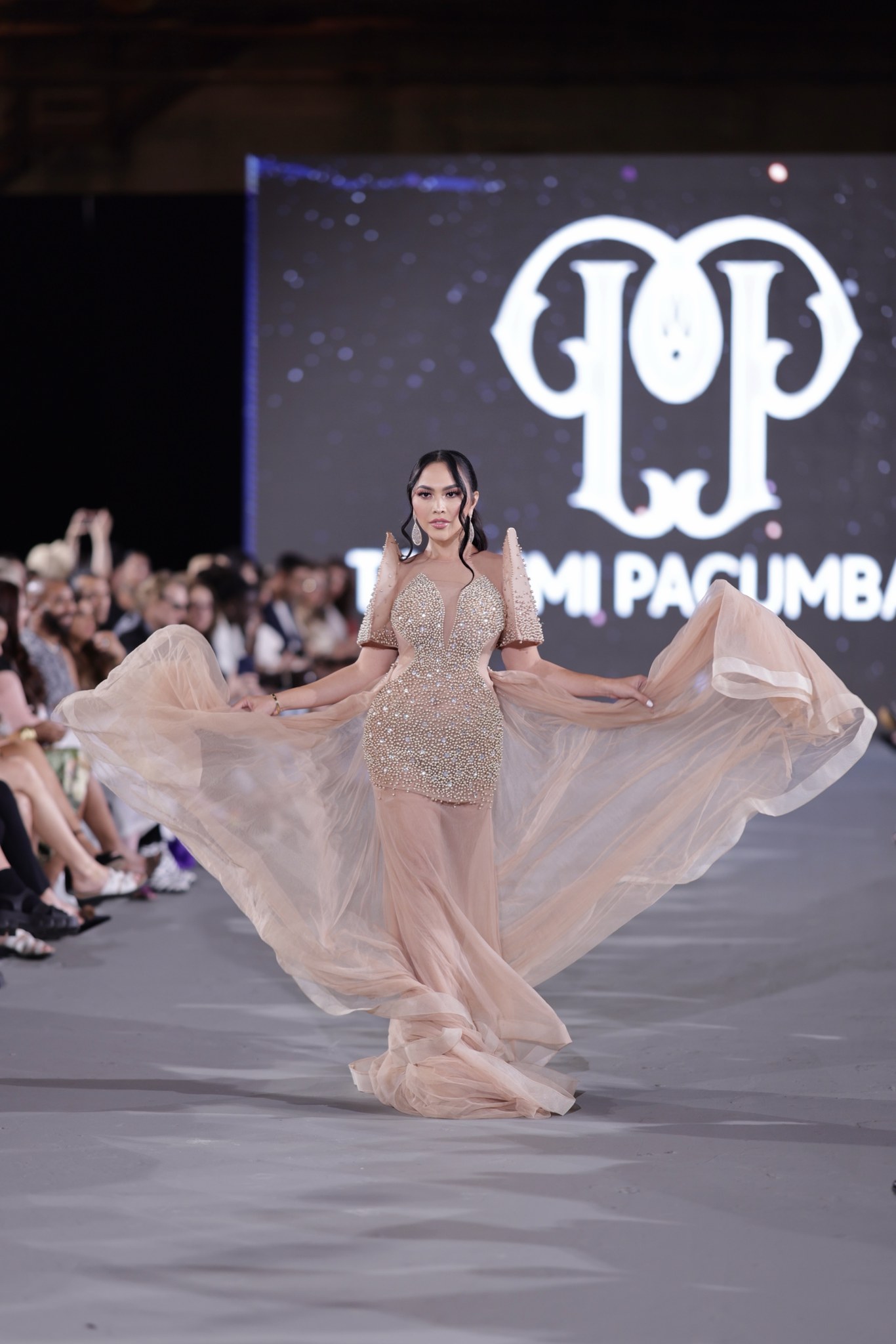 Sofhia Flores on the runway in front of the Toshimi Pacumbala backdrop