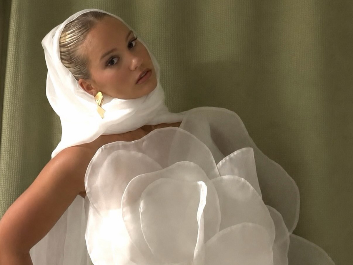 Sophie Rann in a white organza hood, looking back at the camera